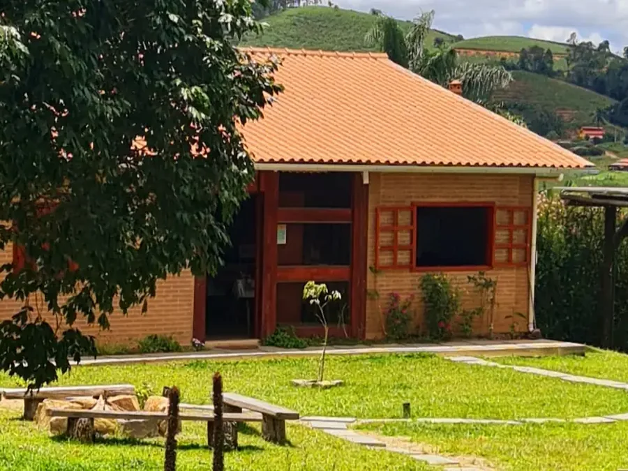 Jardim com jabuticabeira, fogueira e as Cabanas Lua e Estrela ao fundo